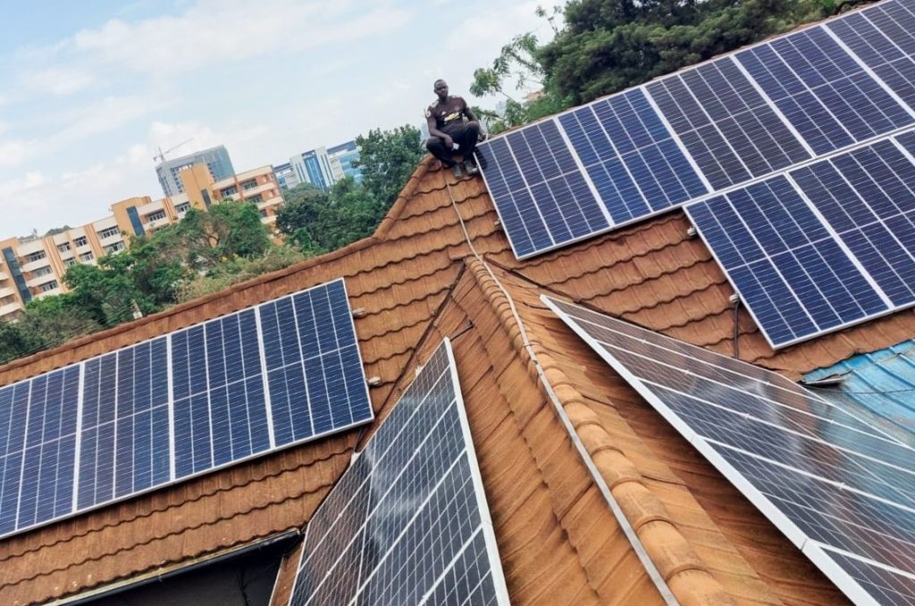 Worker on the roof with the solar plant of Yujo Izakaya, Kampala, Uganda.